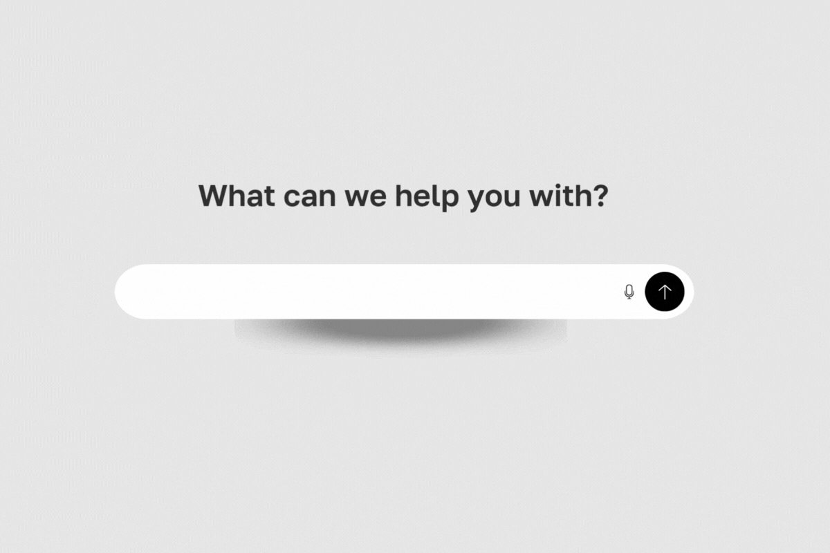 Animated image showing a search bar beneath the text "What can we help you with?" Various prompt-style questions appear one by one in the search bar, including: – “I need a strategy to use AI in our workflow” – “We don’t know which tools to use” – “We tried AI but didn’t get results” – “We don’t have time to train the team” – “How do we scale this?” Each phrase types out and deletes in a loop, illustrating common AI adoption challenges.